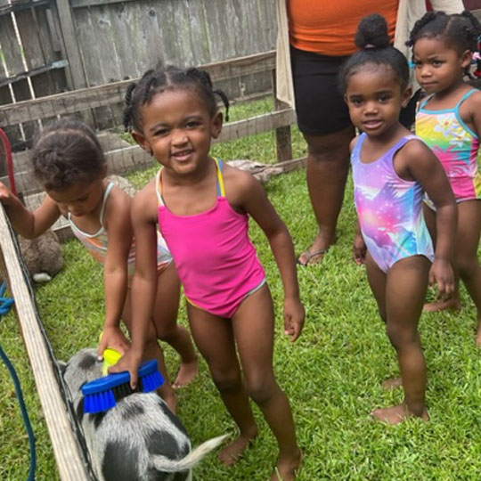 Small children playing with a goat.